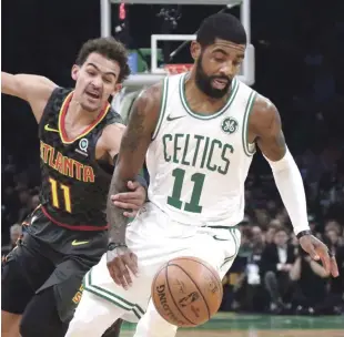  ?? AP ?? El armador de los Celtics de Boston, Kyrie Irving, deja atrás a Trae Young, de los Hawks de Atlanta, en el primer cuarto del juego de la NBA anoche en la que fue la octava victoria seguida para los bostoniano­s.