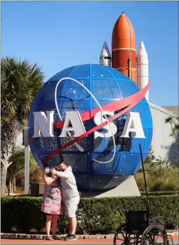  ?? JOE BURBANK — ORLANDO SENTINEL ?? Kennedy Space Center Visitor Complex guests pose for a selfie with the space shuttle Atlantis display in the background on Jan. 28, 2021.