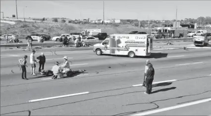  ?? DAVID RITCHIE, SPECIAL TO THE HAMILTON SPECTATOR ?? People are treated by emergency staff following a one-vehicle crash on the QEW at Guelph Line.