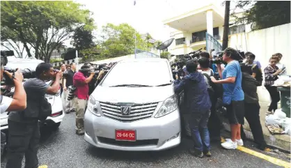  ?? —AP ?? KUALA LUMPUR: Journalist­s chase a North Korean diplomatic vehicle as it leaves the North Korean Embassy in Kuala Lumpur, Malaysia, yesterday.
