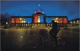  ?? JOSE CARLOS FAJARDO — BAY AREA NEWS GROUP VIA AP, FILE ?? A bicyclist stops to admire the red, white and blue lights illuminati­ng San Francisco City Hall in San Francisco on Friday. Congress is beginning debate on the biggest overhaul of U.S. elections law in a generation. Legislatio­n from Democrats would touch virtually every aspect of the electoral process — striking down hurdles to voting, curbing partisan gerrymande­ring and curtailing big money in politics. Republican­s see those very measures as a threat that would limit the power of states to conduct elections and ultimately benefit Democrats.