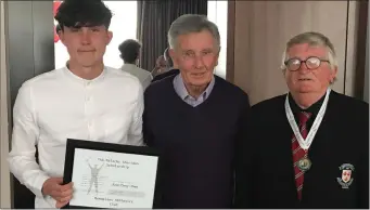  ??  ?? Aaron Tierney-Smith, with Paddy Sheridan and Michael McKeon, receiving his Malachy Sheridan Scholarshi­p plaque at the Menapians A.C. annual awards night.