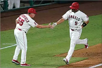  ?? ASHLEY LANDIS / AP ?? The Angels’ Albert Pujols, right, is greeted by third base coach Brian Butterfiel­d as he runs the bases on a solo home run during the fifth inning of Friday’s game against the Rangers in Anaheim. The Angels led the Rangers 6-2 in the top of the ninth inning at The California­n’s print deadline.