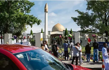  ?? — AFP ?? Emotional day: People gathering outside the Al Noor mosque after the road that runs alongside it was opened to traffic in Christchur­ch.