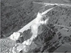  ?? Associated Press ?? ■ This Feb. 11, 2017, file aerial photo released by the California Department of Water Resources shows the damaged spillway with eroded hillside in Oroville, Calif. One year after the closest thing to disaster at a major U.S. dam in a generation,...