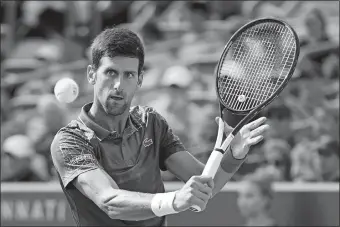  ?? JOHN MINCHILLO/AP PHOTO ?? Novak Djokovic returns to Milos Raonic at the Western &amp; Southern Open on Friday at Mason, Ohio.