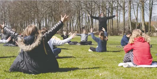  ?? RITZAU SCANPIX/BO AMSTRUP VIA REUTERS ?? Rebekka Hjorth holds a music lesson outdoors with her class at the Korshoejsk­olen school in Randers, Denmark, after it reopened.