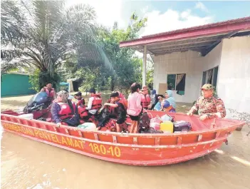  ?? ?? Flood victims being evacuated from their homes to temporary flood relief centres.