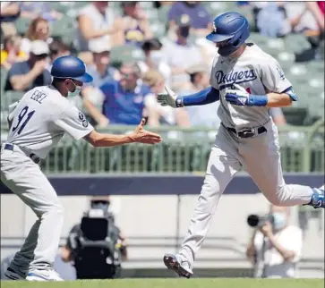  ?? Aaron Gash Associated Press ?? THIRD BASE COACH Dino Ebel, left, congratula­tes AJ Pollock following Pollock’s first-inning grand slam. Pollock and Matt Beaty became the first Dodgers teammates with at least seven RBIs apiece in a game.