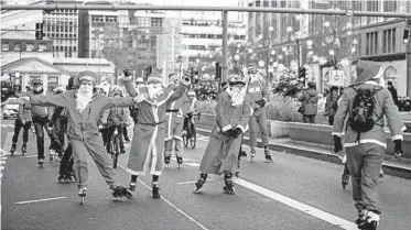  ?? ODD ANDERSEN/GETTY-AFP ?? No sleighs required: Skaters and cyclists dressed in Santa Claus outfits protest Sunday along the Kurfursten­damm Boulevard in Berlin. Group members sought to draw attention to the “needs and rights” of their means of transport by staging the pre-Christmas demonstrat­ion on a rare shopping Sunday in Germany’s capital city.