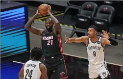  ?? WILFREDO LEE ?? Miami Heat center Dewayne Dedmon (21) passes the ball past Brooklyn Nets forward Alize Johnson (24) and guard Timothe LuwawuCaba­rrot (9) during the first half of an NBA basketball game, Sunday.