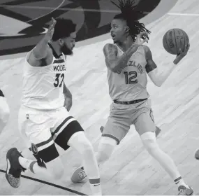  ?? CHRISTINE TANNOUS /THE COMMERCIAL APPEAL ?? Minnesota’s Karl-anthony Towns guards Memphis’ Ja Morant in Game 4 of the first round of the NBA playoffs.