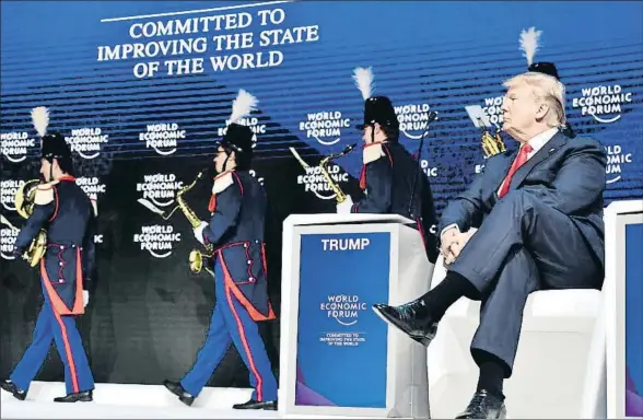  ?? NICHOLAS KAMM / AFP ?? Donald Trump, ayer en Davos, observando la salida de la banda del escenario antes de pronunciar su discurso