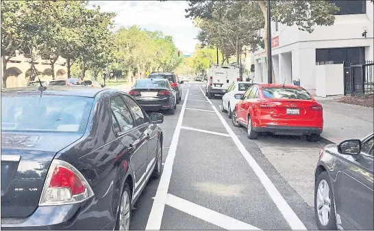  ?? PHOTO BY SAL PIZARRO ?? Cars are parked side-by-side on North Third Street as drivers try to figure out just where they should be as a result of new lane configurat­ions in downtown San Jose.