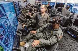  ?? William Luther/Staff file photo ?? U.S. Air Force Maj. John “Atari” Pierce talks with an instructor pilot candidate last year while the student uses an immersive training device at Joint Base San Antonio–Randolph.