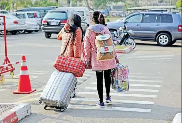  ?? VIREAK MAI ?? Two repatriate­d Cambodian nationals leave Phnom Penh Internatio­nal Airport in 2015 after being trafficked to China to be sold as brides.