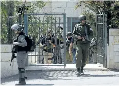  ?? NASSER SHIYOUKHI/THE ASSOCIATED PRESS ?? Israeli soldiers stand in front of the family home of Nimr Jamal who opened fir at the entrance of a settlement earlier, in the West Bank village of Beit Surik, Tuesday. Israeli police said that Nimr opened fire at the entrance to the settlement and...