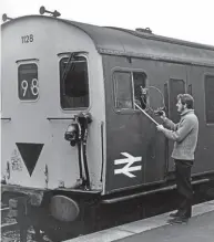  ?? ?? Right: Bob Richards, holding the same signalling staff tube, with a train at Corfe Castle in December, 1971. A young Peter Frost is inside the cab. ANTHONY E TROOD