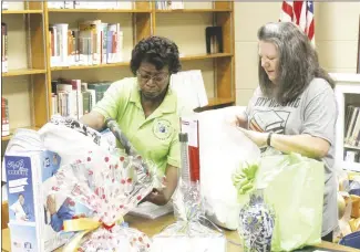  ?? Brodie Johnson • Times-Herald ?? The Forrest City Public Library has a big day planned on Saturday to celebrate the library’s 100th year of existence in Forrest City. The celebratio­n will be held from 11 a.m. to 2 p.m., at the library on South Washington. René Ward, left, and Sheila Gracey, organize door prizes that will be given away at the event.