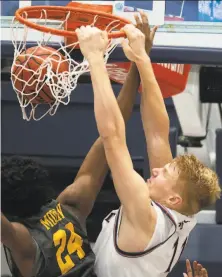  ?? D. Ross Cameron / Associated Press ?? St. Mary’s forward Matthias Tass throws down two over Long Beach State’s Joshua Morgan on his way to 22 points.