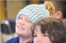  ?? MARLA BROSE/JOURNAL ?? Wearing a hat he knitted, Madison Middle School student Matt Aley, along with other students in the school’s autism program, presents the hats they knitted to donate to young patients at Presbyteri­an Hospital. “It’s enjoyable. Sometimes things are just...
