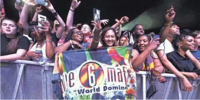  ?? ?? Three 6 Mafia fans cheer as the iconic rap group performs on Beale Street Music Festival’s opening night at Liberty Bowl Park on Friday.