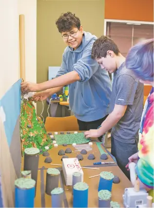  ??  ?? Angel Aguirre Miramontes, from left, works with Nicholas Martinez and Kory Wagener to create Big Dam City on Wednesday. The three are a part of a team of eighth-graders that competed Saturday in the Future City Competitio­n in Albuquerqu­e.