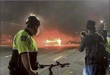  ?? Erin Tiernan / boston Herald ?? boston Police watch a cruiser burn on the night George Floyd protests turned violent this spring.