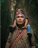  ??  ?? A member of the Achuar tribe with his child in the Amazon forest, Sharamenza, Ecuador. Photograph: Dan Lior