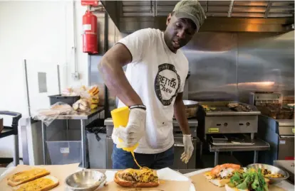  ?? Photos by Jessica Christian / The Chronicle ?? GW “Chef ” Chew, who received a loan from the Runway Project, creates sandwiches at the Veg Hub in Oakland.