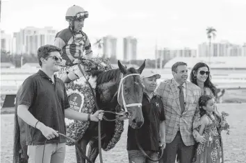  ?? D.A. VARELA dvarela@miamiheral­d.com ?? Jockey John R. Velazquez and Fierceness, with owner Mike Repole and his family, gather for a photo after winning the 73rd running of the Florida Derby at Gulfstream Park in Hallandale Beach on Saturday.