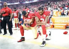 ?? Marcio Jose Sanchez/Associated Press ?? ■ San Francisco 49ers safety Eric Reid (35) and quarterbac­k Colin Kaepernick (7) kneel during the national anthem on Sept. 12, 2012, before a game against the Los Angeles Rams in Santa Clara, Calif.