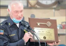  ??  ?? Former Hammond Chief of Police John Doughty holds up a key to the city, presented to him Friday by Hammond Mayor Thomas McDermott Jr.