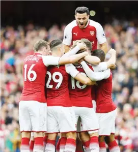  ??  ?? Monreal is congratula­ted by his Arsenal team-mates after scoring his second goal for the north London outfitm at Emirates Stadium yesterday