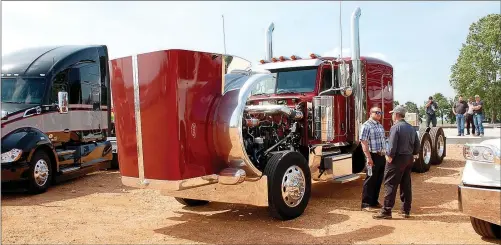  ?? Hunter McFerrin/Herald-Leader ?? Two men discuss what they like most about the engine of the nearby red truck.