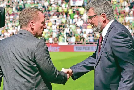  ??  ?? Gritted teeth: Rodgers and Levein shake hands at the end of Sunday’s win for Celtic at Tynecastle