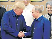  ??  ?? Donald Trump and Russian President Vladimir Putin wore traditiona­l Vietnamese shirts for the ‘family photo’ at the APEC summit in Danang