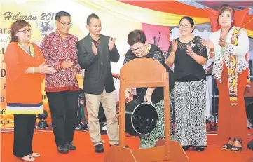  ??  ?? Doris striking a gong to mark the occasion while other VIPs look on.