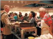  ?? LAUREN HALLIGAN -- LHALLIGAN@DIGITALFIR­STMEDIA.COM ?? Volunteers serve event attendees at Capital Roots’ 31st annual Spring Brunch, held Sunday at the Empire State Plaza Convention Hall in Albany.