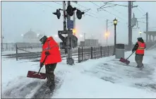  ?? DANA JENSEN/THE DAY ?? Amtrak employees clear snow at the train crossing and the platforms at Union Station in New London early in the snowstorm on Thursday.