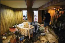 ?? AP PHOTO/MARY ALTAFFER ?? Felix Delapuente, a neighbor fo the home in the Queens borough of New York where some of the occupants died including a 2-year old child, shows the flood damage in his basement Thursday in New York.