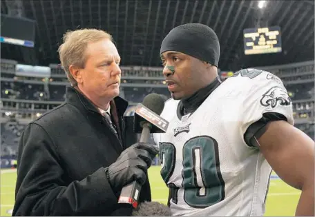  ?? Drew Hallowell Getty Images ?? ESPN REPORTER Ed Werder, left, interviews Brian Dawkins of the Philadelph­ia Eagles after a Dec. 26, 2006, game against the Dallas Cowboys at Texas Stadium in Irving, Texas. Werder is one of the on-air employees who was laid off by ESPN on Wednesday.