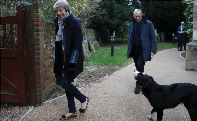  ?? PETER NICHOLLS, REUTERS/SCANPIX ?? Theresa May og mannen Philip var ute og spaserte søndag, mens en hund virket vennlig stemt. Hvor veien går er ikke godt å si, men pilene peker ut av EU.