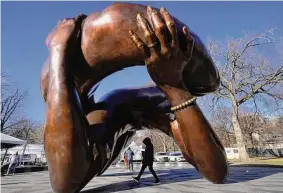  ?? Steven Senne/Associated Press ?? A passerby walks under a sculpture dedicated to Dr. Martin Luther King Jr. and Coretta Scott King on Jan. 10 in Boston.