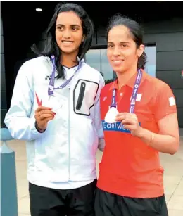  ??  ?? P. V. Sindhu and Saina Nehwal pose with their World Championsh­ips silver and bronze medals respective­ly outside the Emirates Arena in Glasgow, Scotland.