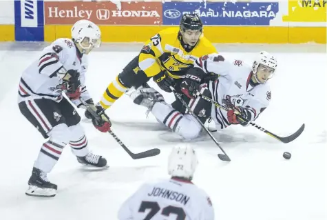  ?? JULIE JOCSAK/ POSTMEDIA NEWS ?? Justin MacPherson of the Niagara IceDogs tries to keep the puck away from Linis Nyman of the Kingston Frontenacs in OHL action at the Meridian Centre in downtown St. Catharines on Thursday,