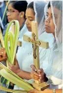  ??  ?? Devotees in prayer on Palm Sunday