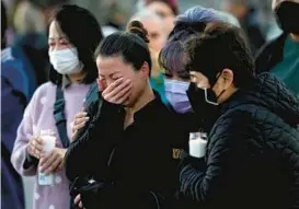  ?? ASHLEY LANDIS/AP ?? Mourners attend a vigil Tuesday outside City Hall in Monterey Park, Calif., blocks from the Star Ballroom Dance Studio, where a gunman killed 11 people late Saturday.