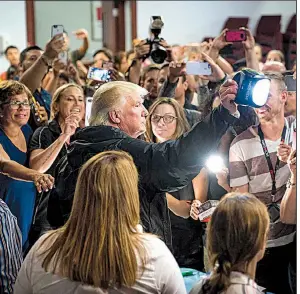  ?? The New York Times/DOUG MILLS ?? President Donald Trump hands out flashlight­s and other supplies Tuesday at a church in Guaynabo, a town just south of Puerto Rico’s capital, San Juan.