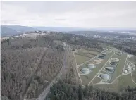  ?? JONATHAN HAYWARD / THE CANADIAN PRESS FILES ?? Kinder Morgan Trans Mountain Expansion Project’s oil storage tank farm, at right with green tanks, in Burnaby.